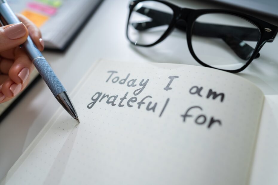 person writing in gratitude journal