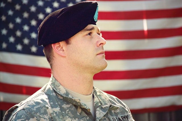 Veteran in front of American flag - Veterans' Susceptibility to Addiction